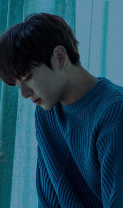 a blue-tinted picture of jungkook gazing down at taehyung’s picture beneath him. the image’s border is a tall rectangle.